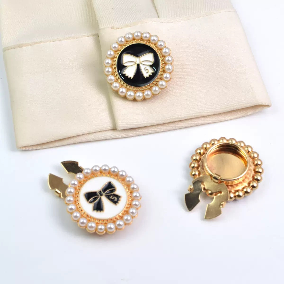 Pearl border gold bow buttons in black and white enamel